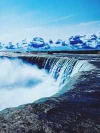 Scenic view of waterfall against sky