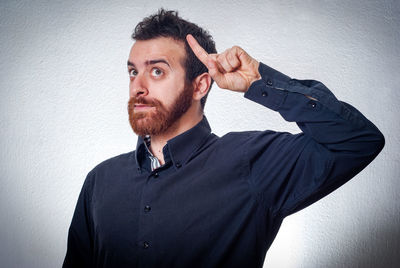 Portrait of young man looking away against wall