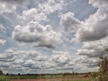 Scenic view of field against cloudy sky