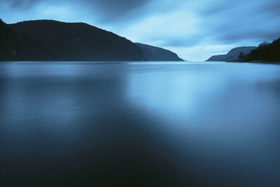 Scenic view of sea and mountains against sky