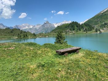 Scenic view of lake by mountains against sky