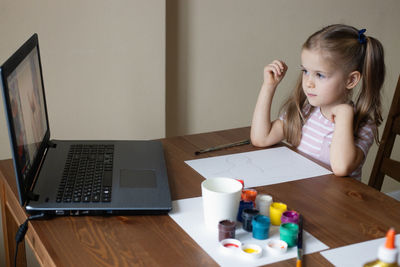 Young woman using laptop at table