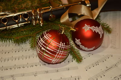 Close-up of christmas ornaments on musical notes