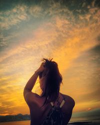 Young woman against sky during sunset