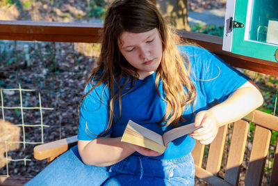 Portrait of young woman reading book