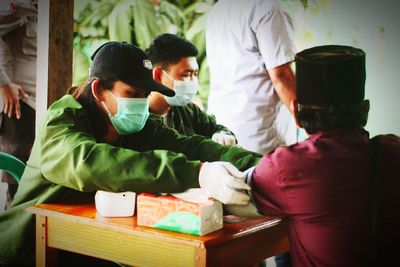 Rear view of people sitting on table