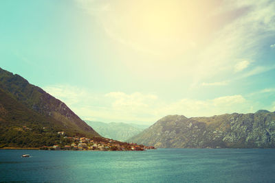 Scenic view of sea and mountains against sky