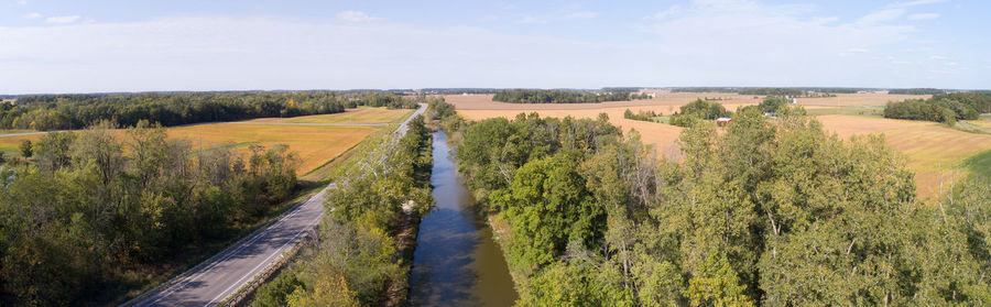 Panoramic view of agricultural field against sky