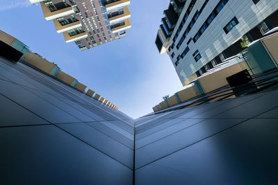 Low angle view of modern buildings against blue sky