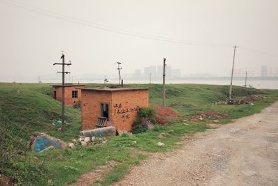 Road amidst field against clear sky