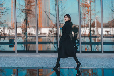 Portrait of woman standing against window