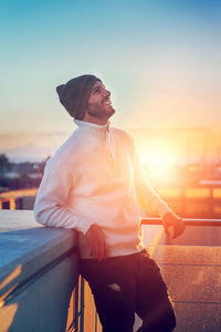 Side view of young man standing against sea