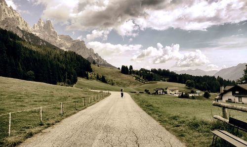 Road amidst field against sky