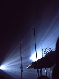 Low angle view of illuminated street lights against sky at night