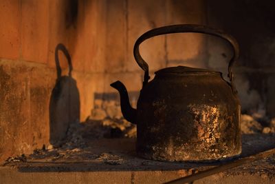 Close-up of old kettle against wall