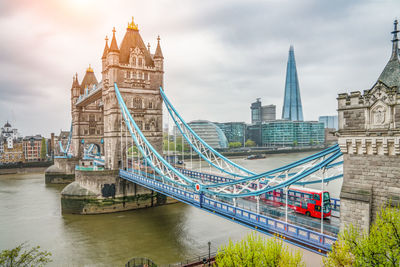 View of bridge over river by buildings in city