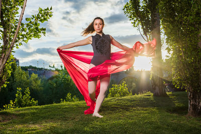 Portrait of young woman standing on field