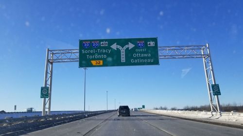 Road sign against clear blue sky