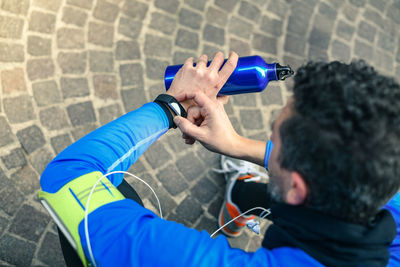 Rear view of man photographing against blue umbrella