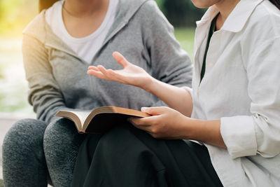 Midsection of man holding book