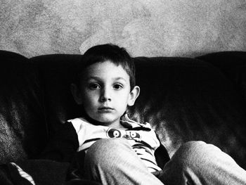 Portrait of boy sitting on sofa at home