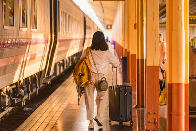 Rear view of woman walking on train