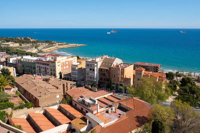 High angle view of townscape by sea against sky