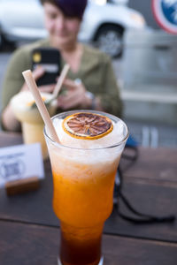 Woman photographing drink served on table