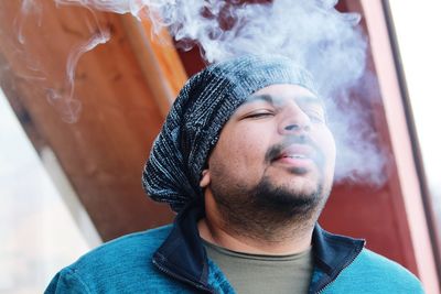 Close-up of young man exhaling smoke