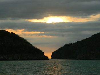 Scenic view of sea and mountains against sky during sunset