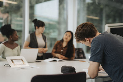 Young male student studying at table in university