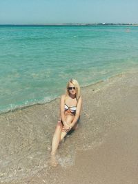 High angle view of sensuous woman relaxing on shore at beach