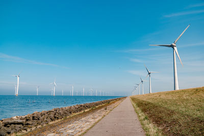 Wind turbines on land against sky