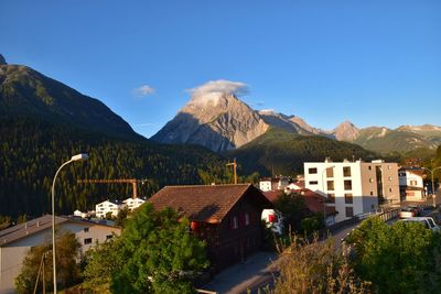 Town by mountains against clear sky