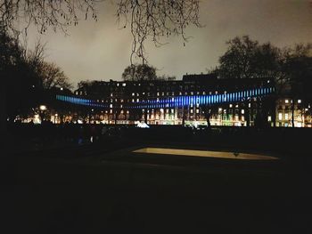 Illuminated road against sky at night