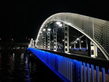 Illuminated bridge over river at night