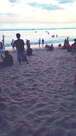 People at beach against sky