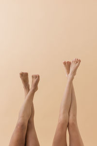 Cropped hands of woman holding jigsaw pieces against white background