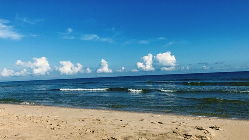 Scenic view of beach against blue sky