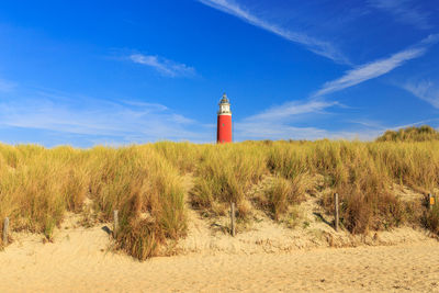 Lighthouse at the beach against sky