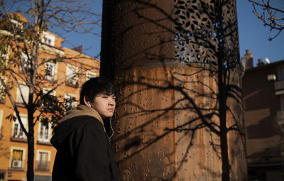 Asian teenage boy with earphones on street. madrid. spain