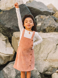 Portrait of a smiling girl standing on rock