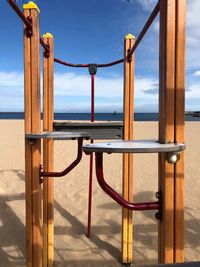 Metal railing by sea against sky