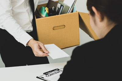 Midsection of man holding paper at home