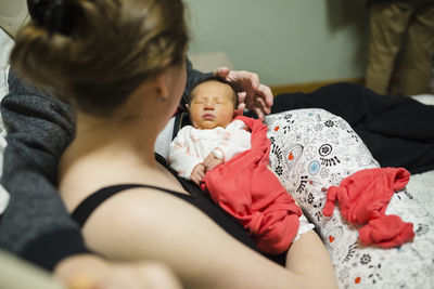 New parents cuddle with newborn baby girl in hospital room