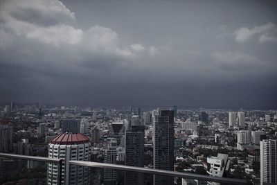 Aerial view of cityscape against cloudy sky