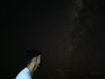 Man photographing against sky at night