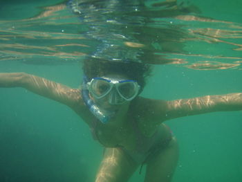 Portrait of woman wearing scuba mask swimming in sea