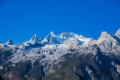 Snowcapped mountains against clear blue sky