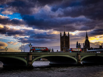 Bridge over river against cloudy sky